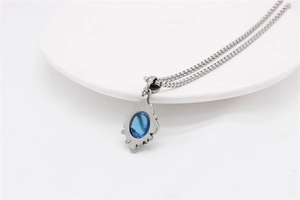 Close-up of vintage titanium steel pendant with blue sapphire and baroque pattern