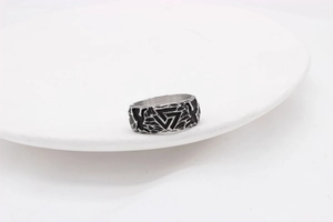 Detailed view of silver Viking Valknut ring with black triangle motif and stone texture