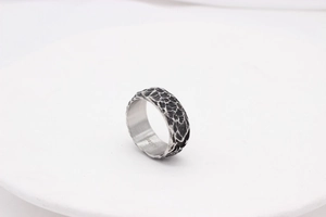 Macro detail of vintage hammered steel ring with distressed texture and inner engraving