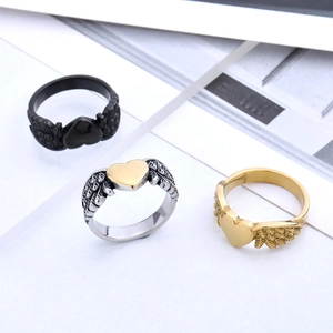 Three angel wing heart rings in black, gold, and silver finishes shown on white background