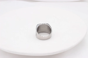 Macro view of silver titanium steel signet ring with side engraving on white display