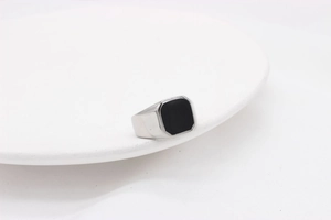 Détail d'une pierre noire carrée géométrique sur une bague en acier argenté poli