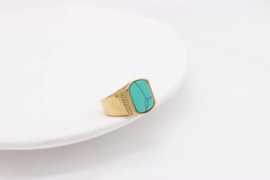 Detail eines Vintage-Goldstahlrings mit rechteckigem Türkis und griechischen Motiven