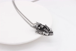 Detailed close-up of retro silver skull pendant with vintage steel chain necklace