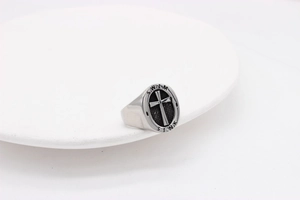 Detail of vintage steel signet ring with black cross texture and SINK SWIM engraving
