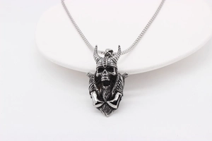 Close-up of a retro Viking skull pendant with horned helmet on a silver snake chain