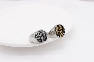 Dettaglio macro di anelli con sigillo Albero della Vita in acciaio argento nero e oro