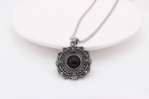 Macro view of Gothic necklace pendant with black gemstone and vintage silver engraving