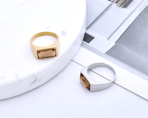 Detail of minimalist gold and silver signet rings with champagne rectangular gemstones