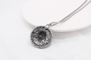 Vue macro du pendentif médaillon tête de mort vintage avec relief ciselé et finition vieillie