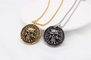Gros plan détaillé sur des pendentifs de crâne rétro punk en finitions or et argent antique