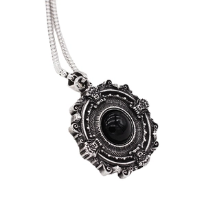 Gothic vintage silver pendant necklace with embossed details and a black gemstone
