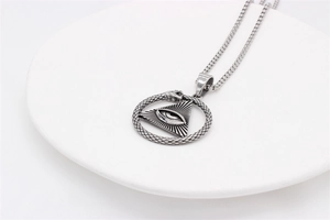 Detailed macro view of vintage stainless steel All-Seeing Eye pendant on white display