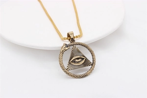 Macro detail of vintage Egyptian Pharaoh Eye of Providence pendant with Ouroboros snake