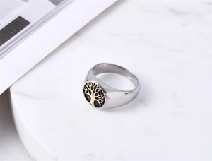 Detail of vintage silver ring with golden tree of life emblem on marble display