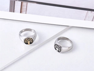 Macro shot of polished stainless steel Tree of Life signet rings with detailed engraving