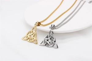 Gros plan sur des pendentifs nœud celtique Triquetra en or et argent sur chaîne à billes