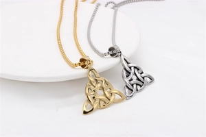 Gros plan des pendentifs Triquetra dorés et argentés avec chaînes perles sur céramique