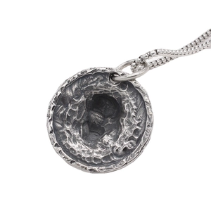 Collier vintage en acier titane avec un pendentif rond texturé de style météorite