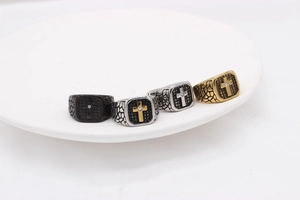 Detailansicht von vier Vintage-Kreuzringen für Herren in Schwarz, Gold und Silber