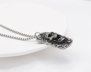 Details des Vintage-Punk-Totenkopf-Anhängers in Altsilber mit strukturierter Felsoberfläche