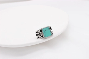 Detail of vintage signet ring with green turquoise stone and silver cutout texture