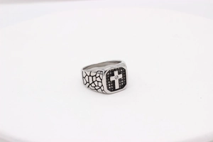 Nahaufnahme des Retro Herren-Ringes aus Stahl mit Kreuz, schwarzem Netz und Riss-Struktur