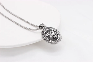 Macro detail of Nordic Viking wolf totem pendant with rune engravings on a steel chain