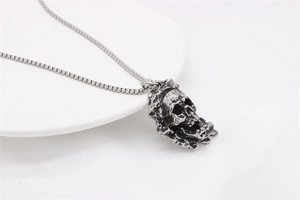Nahaufnahme des Vintage-Silber Totenkopf-Anhängers mit Lavatextur und quadratischer Kette