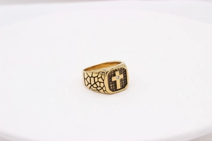 Makrodetail eines goldenen Herren-Kreuzrings mit Retro-Riss-Textur und kleinem Zirkonia