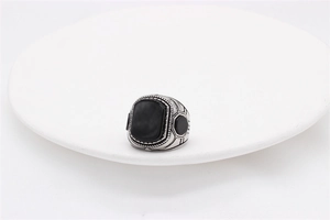 Detail of vintage men's steel ring with large black agate stone and geometric engravings