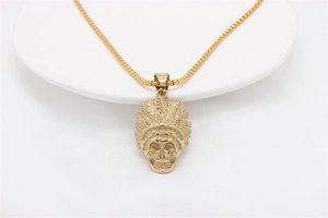 Detailed view of vintage gold Indian skull pendant with intricate feather crown engraving