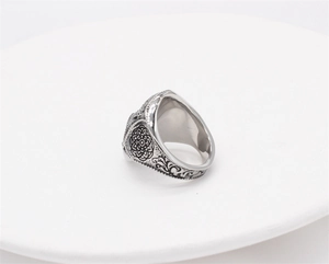 Detailed close-up of retro silver skull ring with ornate mandala and vintage floral carvings