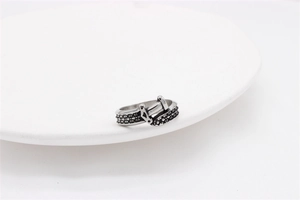 Detailed view of retro punk belt buckle ring with black stones and oxidized finish