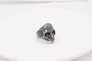 Macro view of vintage silver skull ring with detailed mandala floral engravings