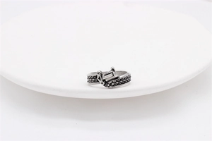 Close-up of vintage punk silver ring with belt buckle design and cross relief pattern