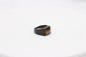 Detail of matte black stainless steel ring featuring a rectangular tiger eye stone inlay