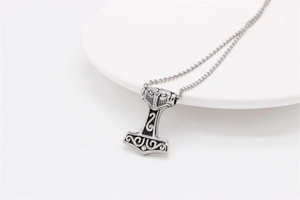 Macro view of vintage Mjolnir pendant with detailed Viking Norse engravings on steel