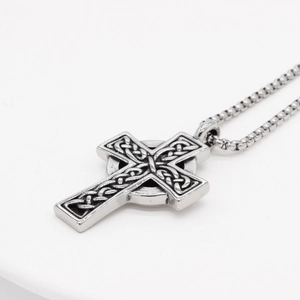 Macro view of Celtic cross pendant with intricate vintage textures and beaded chain detail