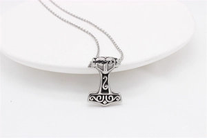 Detailed view of Viking Mjolnir pendant with intricate knotwork patterns on white ceramic