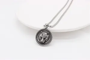 Dettaglio ravvicinato di un ciondolo con testa di tigre in argento su catena veneziana