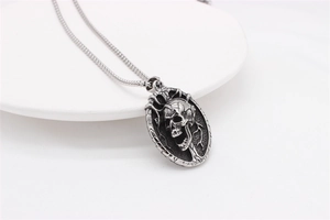 Detailed view of gothic skull pendant necklace in vintage stainless steel on white surface