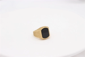 Detail eines goldenen Siegelrings für Herren mit schwarzem Edelstein und feiner Körnung