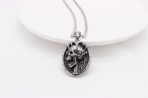 Macro detail of retro stainless steel skull pendant with gothic cross and dead wood engraving