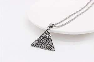 Detailed macro of vintage titanium steel pyramid pendant with unique porous texture
