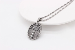 Detailed view of vintage oval cross pendant on a sturdy box chain with polished relief