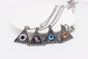 Detail of four pyramid pendants with all-seeing eye and praying hand glass cabochons