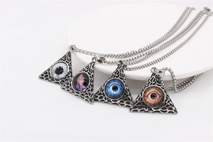 Detail of vintage Masonic pyramid pendants with evil eye and praying hand designs