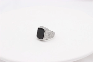 Nahaufnahme eines Vintage-Herrenrings mit schwarzem Edelstein und Wabenmuster-Band