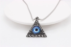 Macro shot of vintage All-Seeing Eye pyramid pendant with detailed silver-tone metal texture